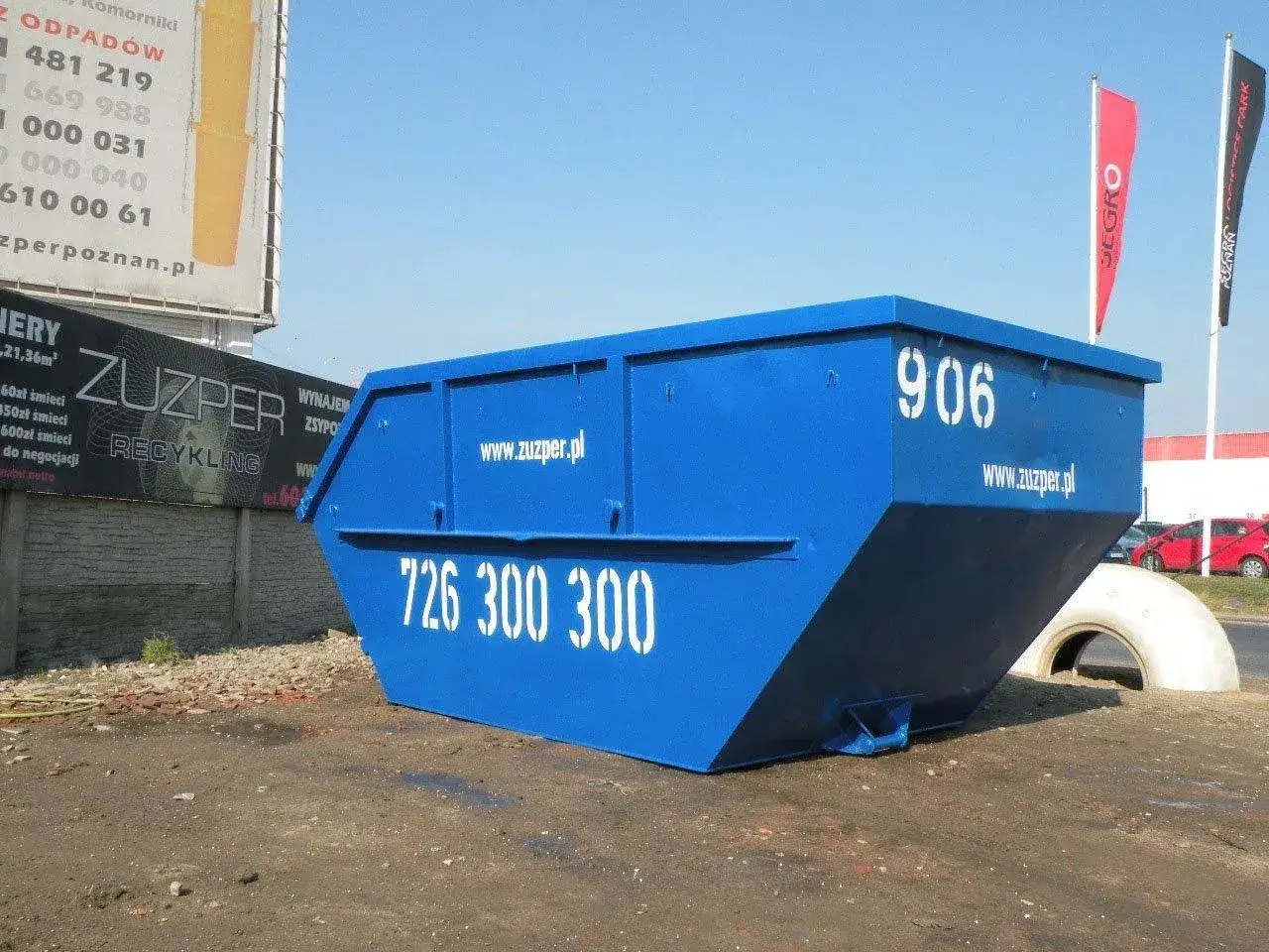 Niebieski kontener na śmieci z numerem 906 i telefonem 726 300 300. Dowiedz się, ile kosztuje kontener na śmieci od ZUZPER.